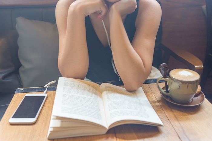 woman reading a book at a cafe